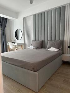een slaapkamer met een groot bed met een groot hoofdeinde bij SeaSide Infinity Resort in Mamaia Nord – Năvodari