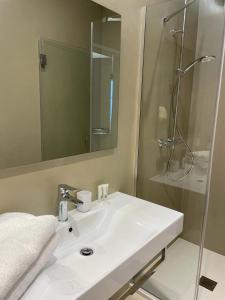 a bathroom with a white sink and a shower at Viva Properties in Ouranoupoli