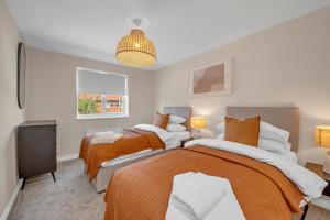 a bedroom with two beds and a television at The Grange Luxe3 in Ipswich