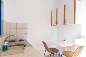 a kitchen with a sink and a table with chairs at Villa Rodanthi Sivota in Syvota