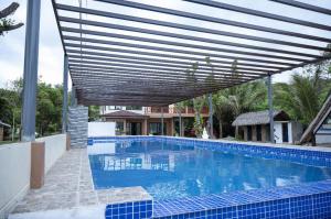 a large swimming pool with a wooden canopy over it at La Jose Beach Resort in Pagudpud