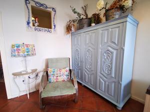 une chaise et un cabinet dans une pièce dans l'établissement Charming Portuguese style apartment, for rent "Vida à Portuguesa", "Sardinha" Alojamento Local, à Portimão