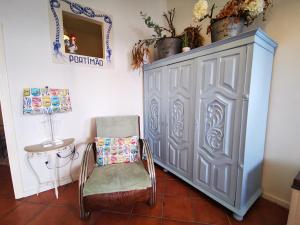 a chair and a cabinet in a room at Charming Portuguese style apartment, for rent "Vida à Portuguesa", "Sardinha" Alojamento Local in Portimão +39 photos