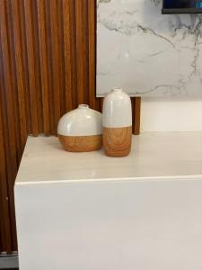zwei Vasen auf einem weißen Tisch in der Unterkunft Appartement luxueux au cœur de la ville in Douala