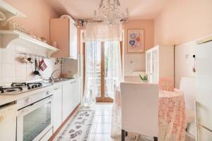 eine Küche mit weißen Schränken und einem Kronleuchter in der Unterkunft Fiorenza House in Luisago