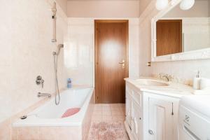 ein Bad mit einer Badewanne, einem Waschbecken und einer Dusche in der Unterkunft Fiorenza House in Luisago