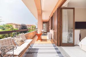 a patio with a couch and a tv on a balcony at Fiorenza House in Luisago