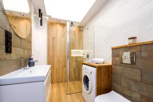 łazienka z pralką i umywalką w obiekcie Apartamenty Usteckie w Ustce