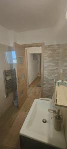 a bathroom with a white sink and a toilet at Apartament 2 camere in Râmnicu Vâlcea +11 photos