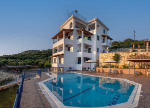 a hotel with a swimming pool in front of a building at Villa Rodanthi Sivota in Syvota