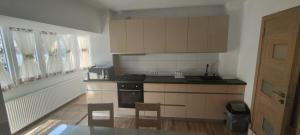 a kitchen with a stove and cabinets and a table at Apartament 2 camere in Râmnicu Vâlcea