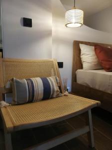 a bedroom with a bench with a bed and a lamp at Simά Apartments in Heraklio Town
