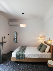 a bedroom with a bed and a mirror and lights at Simά Apartments in Heraklio Town
