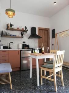 a kitchen with a table and two chairs and a stove at Simά Apartments in Heraklio Town
