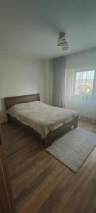 a bedroom with a bed in a room with a window at Apartament 2 camere in Râmnicu Vâlcea