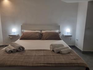 una camera da letto con un grande letto con due asciugamani di Residenza Don Camillo a Mondello