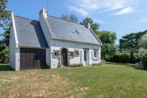 une petite maison blanche avec une cour d'herbe dans l'établissement Douce parenthese en famille a Sarzeau, à Sarzeau