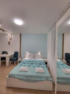 - une chambre avec un lit et deux chaises bleues dans l'établissement HARMONY Suites (Savska ulica), à Sajmište