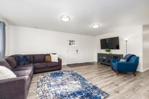 uma sala de estar com um sofá e uma televisão em Manor Getaway em Anchorage