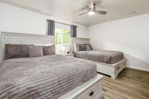 a bedroom with two beds and a ceiling fan at Manor Getaway in Anchorage