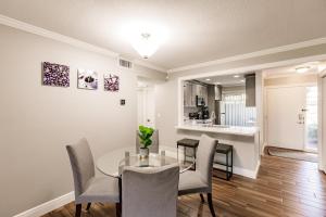 a dining room with a table and chairs and a kitchen at Bright 2 bedroom 2 bath condo with pool in Sarasota +23 photos