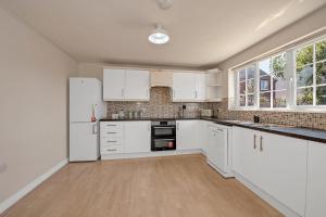 an empty kitchen with white cabinets and appliances at The Grange Luxe2, 5 Bedroom House,Spacious,contractor,family,Internet,free parking,group,study,relocation,easily accessible in Ipswich,Kesgrave in Ipswich +28 photos