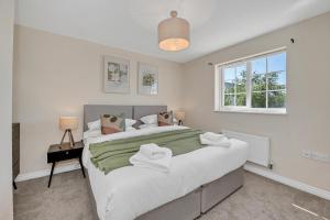 a bedroom with a large bed and a window at The Grange Luxe2, 5 Bedroom House,Spacious,contractor,family,Internet,free parking,group,study,relocation,easily accessible in Ipswich,Kesgrave in Ipswich