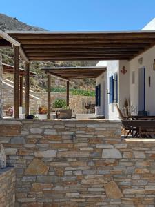an outdoor patio with a stone wall and a wooden pergola at Dream Catcher3 in Agia Theodoti +22 photos
