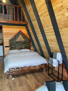 a bedroom in a log cabin with a bed at MEKTA BUNGALOV in Çamlıhemşin