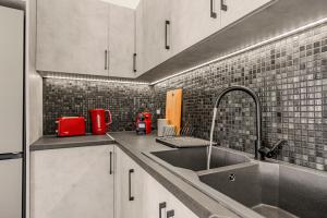 una cocina con fregadero y un aparato rojo en Zana's Villas-Zenia, en Akrotiri