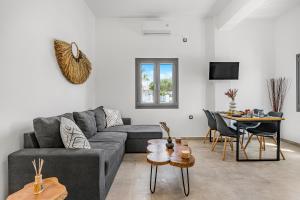 a living room with a gray couch and a table at Zana's Villas-Zenia in Akrotiri