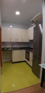 a kitchen with white cabinets and a green floor at Entre Las Catedrales Campo y Mar 1 y 2 in Lourenzá