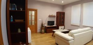 a living room with a white couch and a television at Entre Las Catedrales Campo y Mar 1 y 2 in Lourenzá