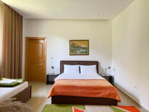 a bedroom with a large bed with orange blanket at Guesthouse Niko in Berat