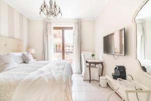 a white bedroom with a bed and a mirror at Fiorenza House in Luisago