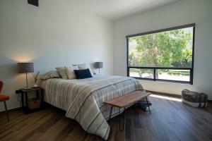 een slaapkamer met een bed en een groot raam bij Casa Alvana in Ensenada