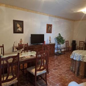 a living room with a table and a tv at Casa de la Gloria in Baños de la Encina