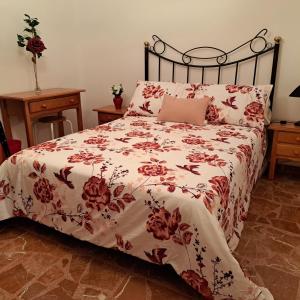 a bed with a red and white comforter with a laptop on it at Casa de la Gloria in Baños de la Encina