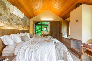 a bedroom with a large white bed in a room at Villa Tanah in São Roque