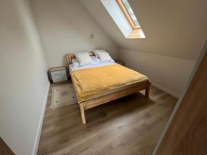 een kleine slaapkamer met een bed op zolder bij Szopówka Pod Grodziskiem in Dukla