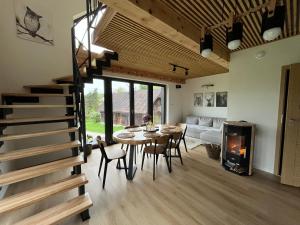 een woonkamer met een tafel en stoelen en een open haard bij Szopówka Pod Grodziskiem in Dukla