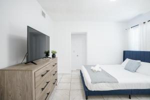 マイアミにあるModern 3-Bedroom in the Heart of Wynwood Art Districtのベッドルーム(ベッド1台、ドレッサー内のテレビ付)