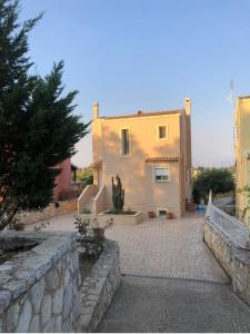 una casa con una pared de piedra junto a un edificio en ioli Corfu maisonette, en Kastanéa