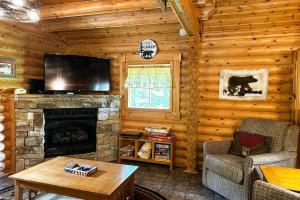 uma sala de estar com lareira e uma televisão de ecrã plano em Pine Cone Cabin em Gatlinburg