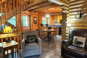 a living room with chairs and a table in a log cabin at Pine Cone Cabin in Gatlinburg
