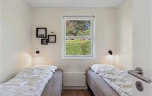 Spodsbjerg的住宿－索利斯特魯德考賓丹麥V號度假屋，白色客房的两张床,设有窗户