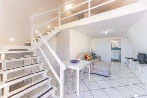 - un escalier blanc dans un salon avec une table dans l'établissement Kisses House - MARINA GRANDE PORT, à Procida