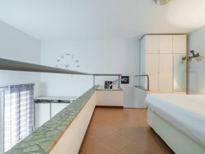 Una habitación blanca con una cama y una cocina. en Lo Specchio di Ferrara, en Ferrara