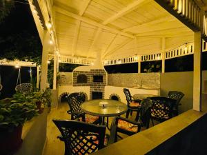 an outdoor patio with tables and chairs and a fireplace at Vila Timona in Eforie Nord