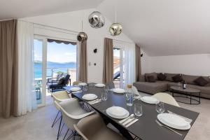 een eetkamer met een tafel en stoelen en een bank bij Apartments Ocrux in Trogir